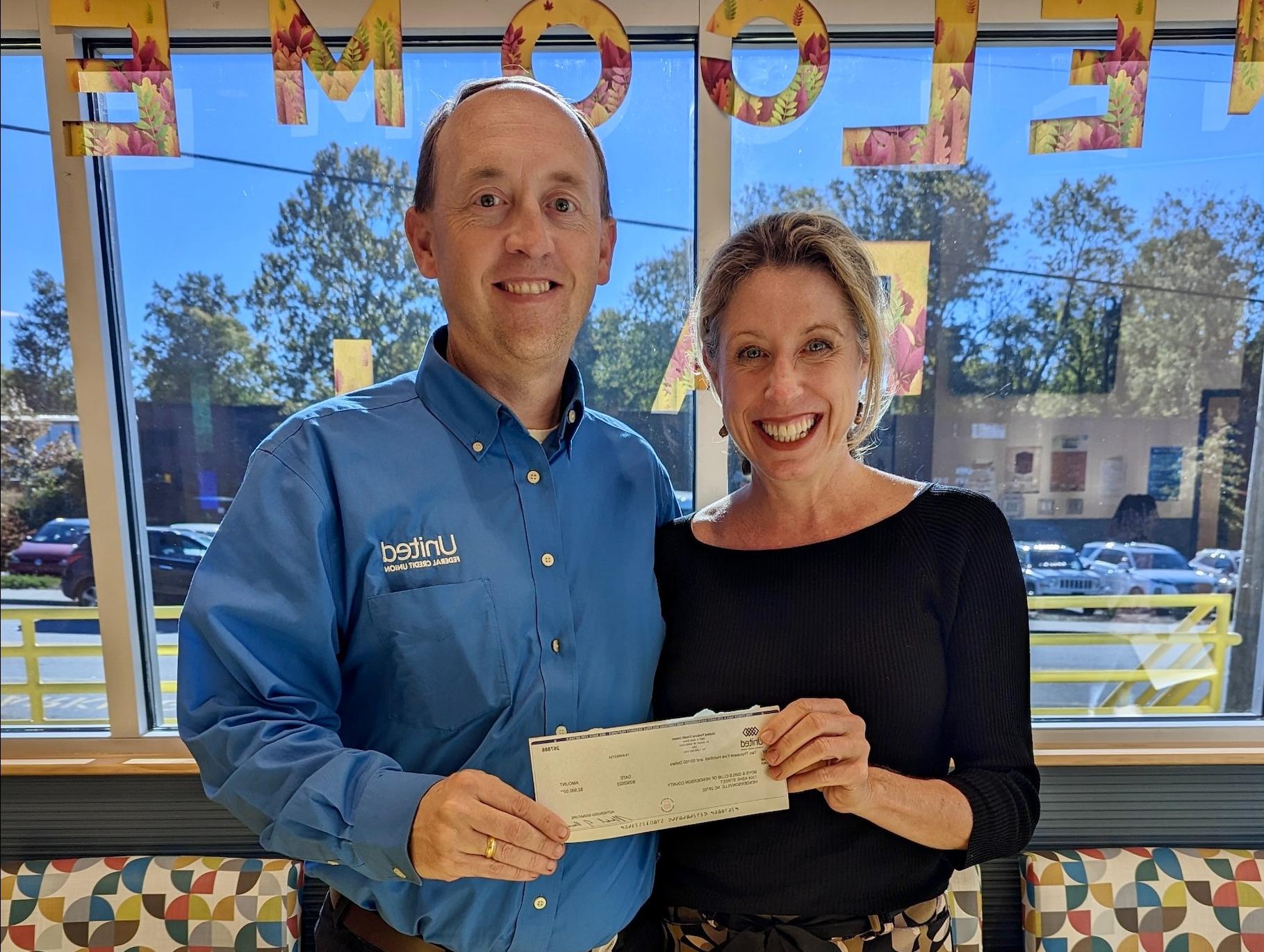 United Federal Credit Union’s Matt Sorrells (right) presents a fundraising check to the Boys & Girl Club of Henderson County’s Julia Hockenberry